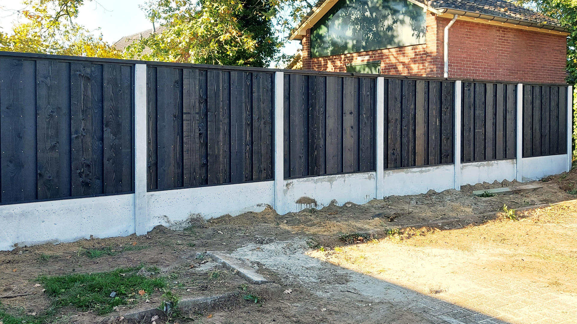 Vuren zwarte schutting met grijs beton